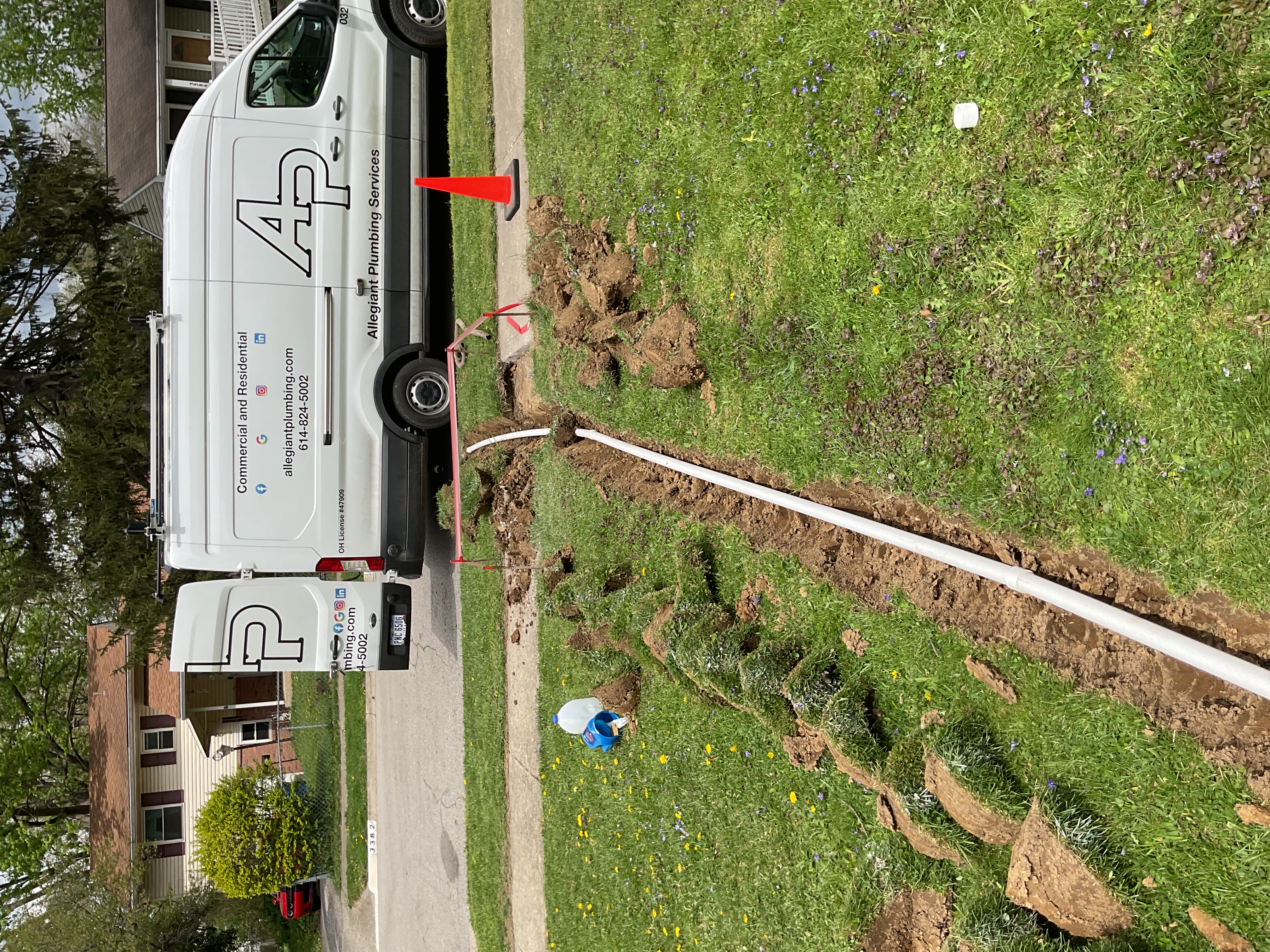 Rigid PVC sump pump discharge trench extending across a Columbus Ohio yard toward municipal storm drainage